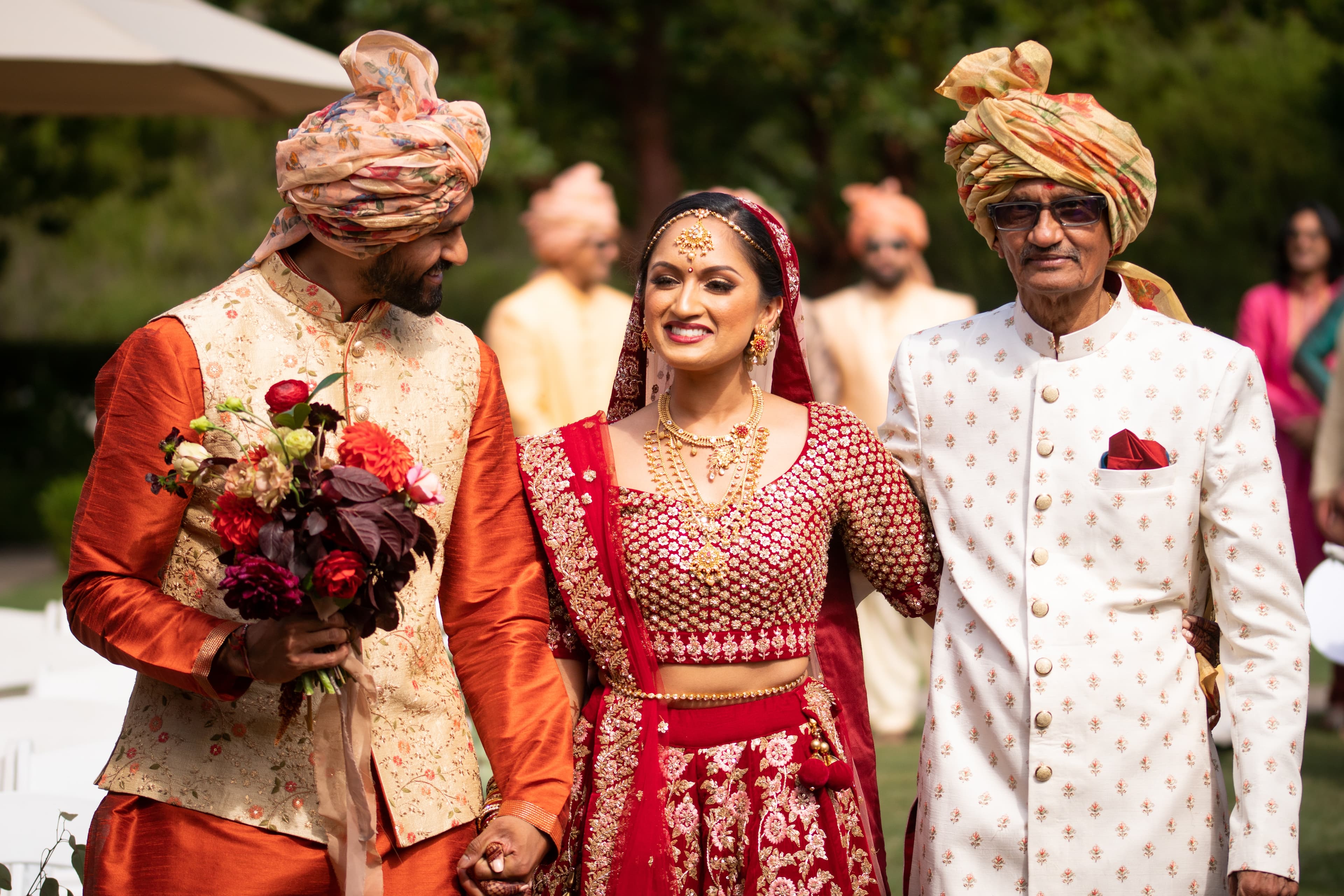 Red lehenga, fathers walking.